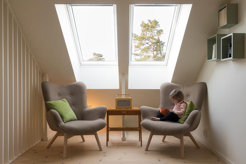 Girl sitting in chair reading a book under sun lights cut home carbon emissions