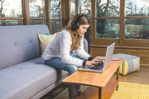 girl on computer in a Global Solariums Sunroom